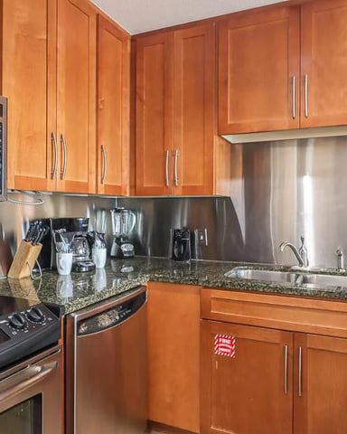 Kitchen with cherry wood cabinets, stainless steel appliances, granite countertops, and sink with window view